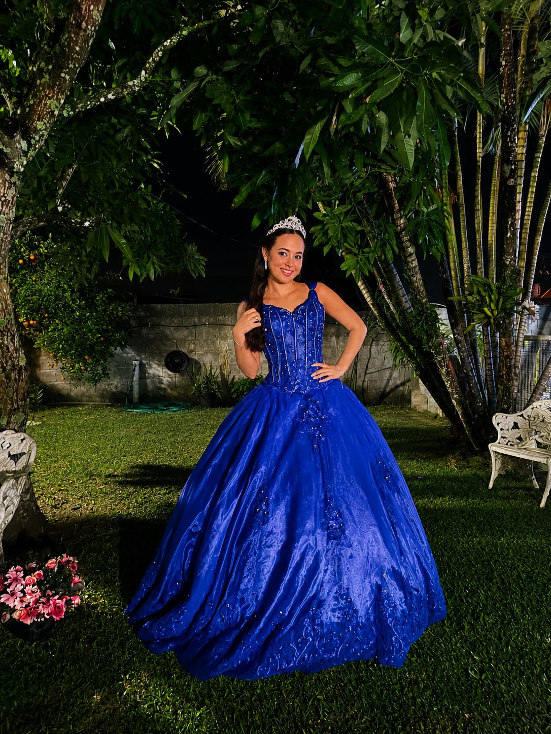 Debutante de vestido azul no jardim à noite