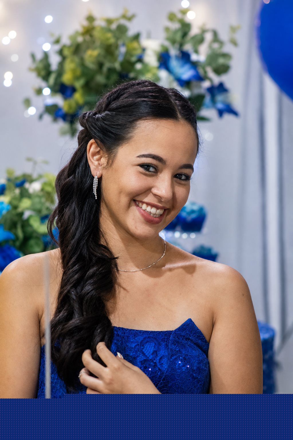 Retrato da debutante de vestido azul sorrindo